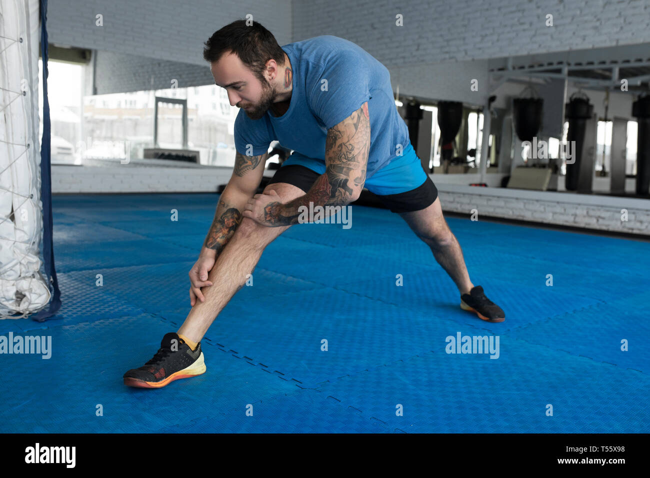 Mid adult man stretching in gym Banque D'Images