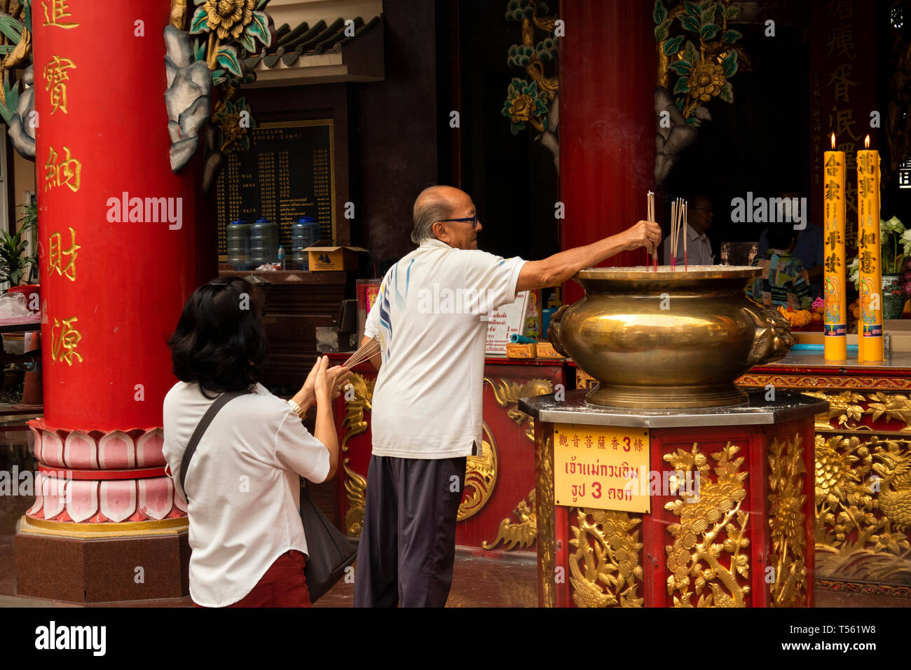 Thaïlande, Bangkok, Chinatown, Thanon Yaowarat, Kuan Yim culte, l'homme et de la femme en prière avec d'encens Banque D'Images