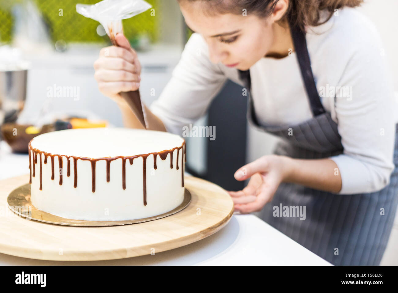 Un Confiseur Comprime Chocolat Liquide A Partir D Une Poche A Douille Sur Une Creme Blanche Biscuit Gateau Sur Un Support En Bois Le Concept De Patisserie Maison La Cuisine Photo Stock Un Confiseur Comprime Chocolat Liquide A Partir D Une Poche A Douille Sur Une Creme Blanche Biscuit Gateau Sur Un Support En Bois Le Concept De Patisserie Maison La Cuisine Photo Stock