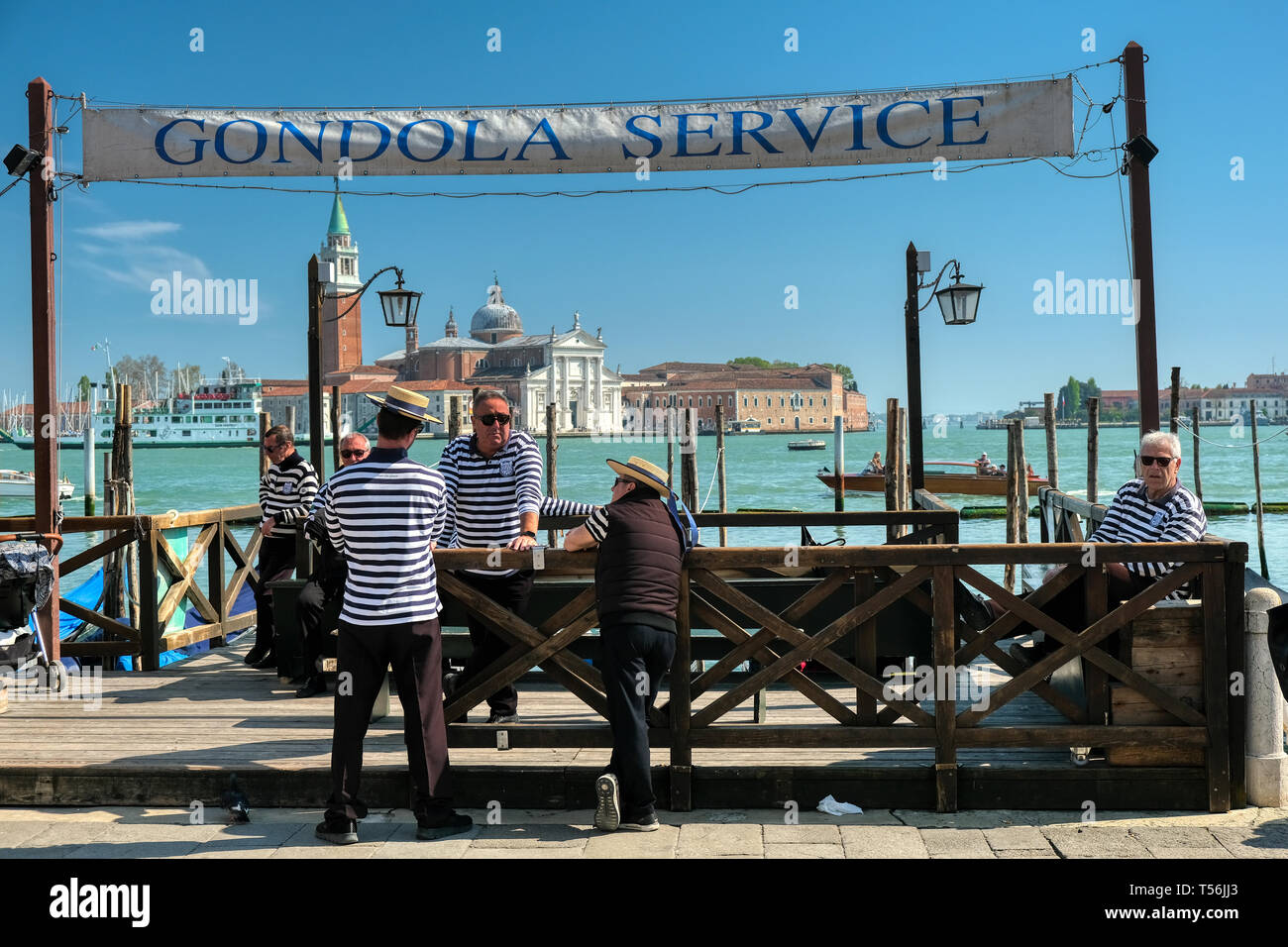 Venise, Italie - 17 Avril 2019 : Gondoliers attendant à gondola service pour les clients à la place Saint Marc à Venise avec l'église San Giorgio Maggiore Banque D'Images