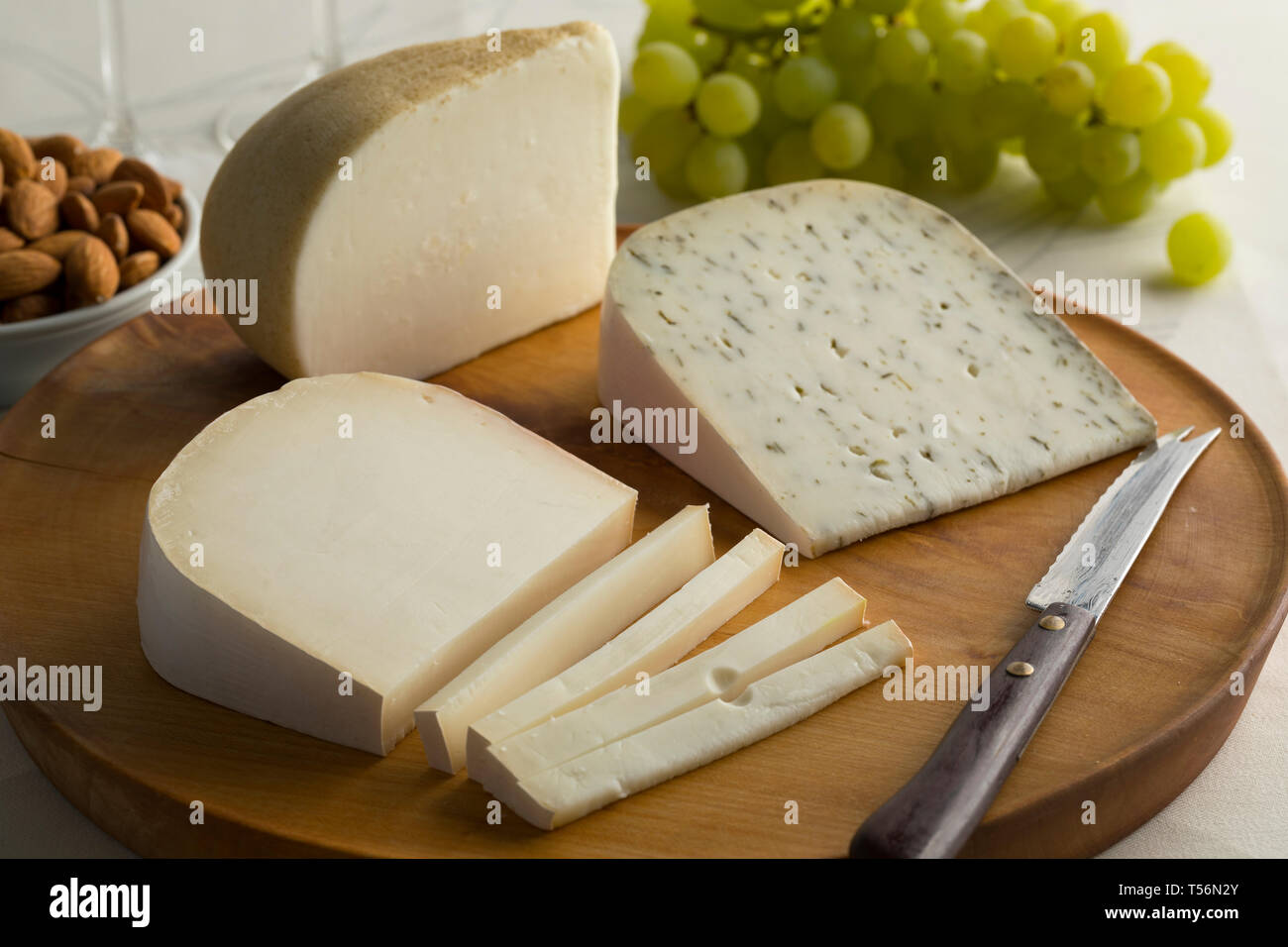 Planche de bois avec la diversité du fromage de chèvre, néerlandais un raisin pour le dessert d'amandes Banque D'Images