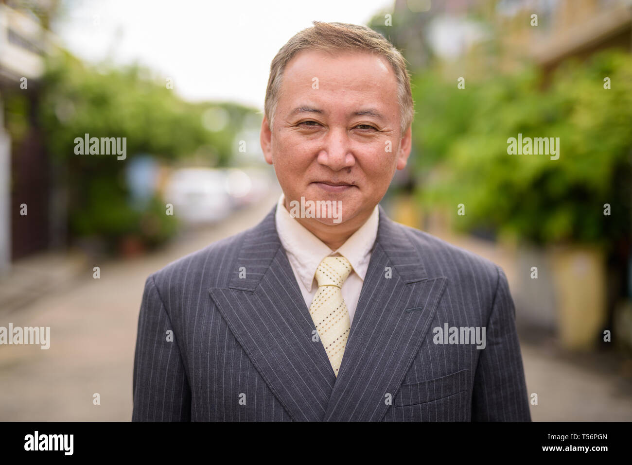 Mature Asian businessman dans les rues à l'extérieur Banque D'Images