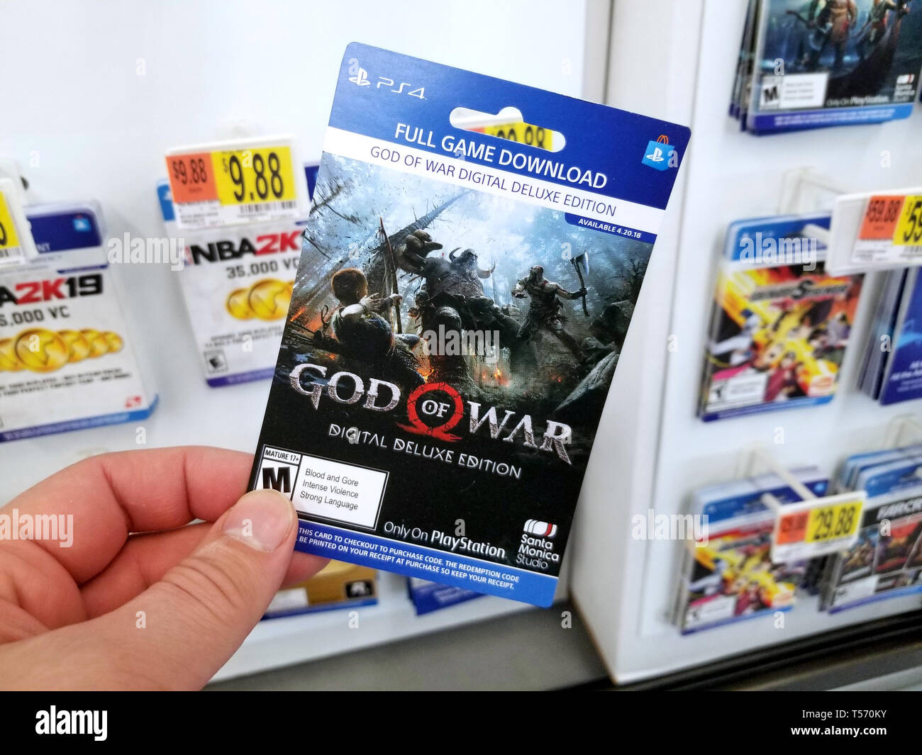PLATTSBURGH, USA - Le 21 janvier 2019 : Plein jeu carte de téléchargement de God of War jeu vidéo dans une main d'un acheteur au magasin Walmart. Banque D'Images