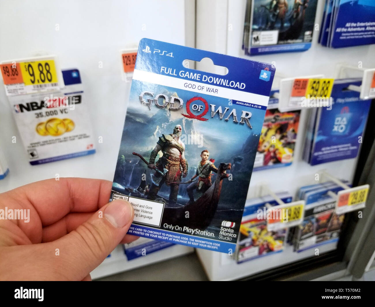 PLATTSBURGH, USA - Le 21 janvier 2019 : Plein jeu carte de téléchargement de God of War jeu vidéo dans une main d'un acheteur au magasin Walmart. Banque D'Images