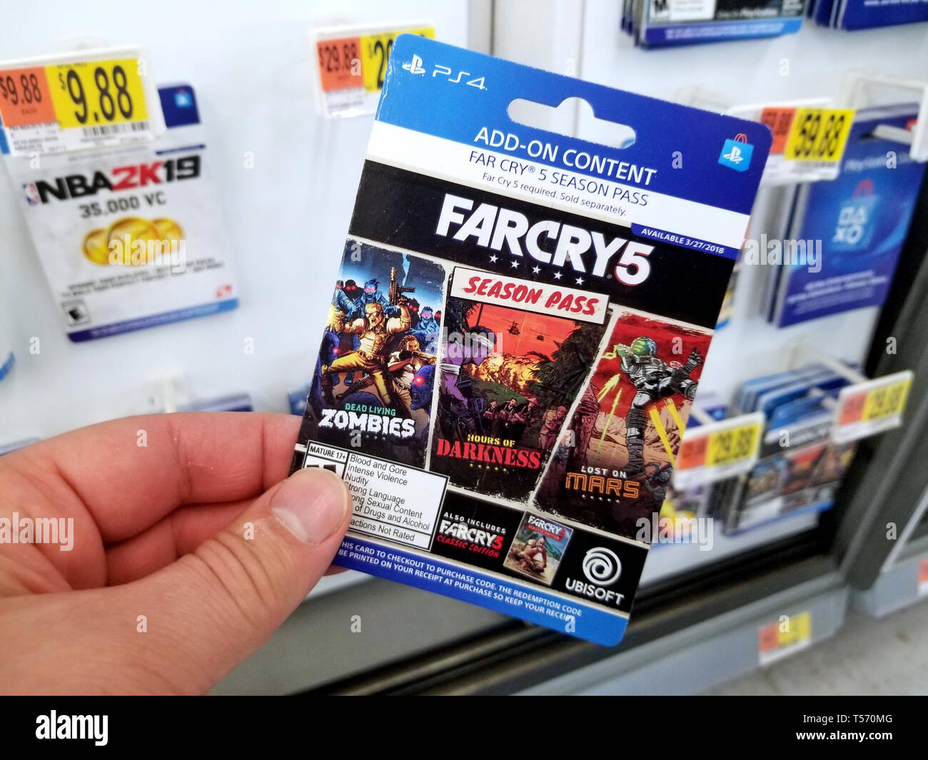 PLATTSBURGH, USA - Le 21 janvier 2019 : carte de saison de Far Cry 5 jeu vidéo dans une main d'un acheteur au magasin Walmart. Banque D'Images