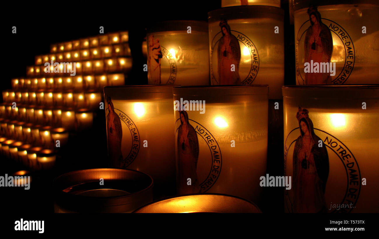 Allumé en rangées de bougies à l'image de Saint Maria, à la Cathédrale Notre Dame, Paris, France organisé soigneusement et affichés sur les lignes à l'église Banque D'Images