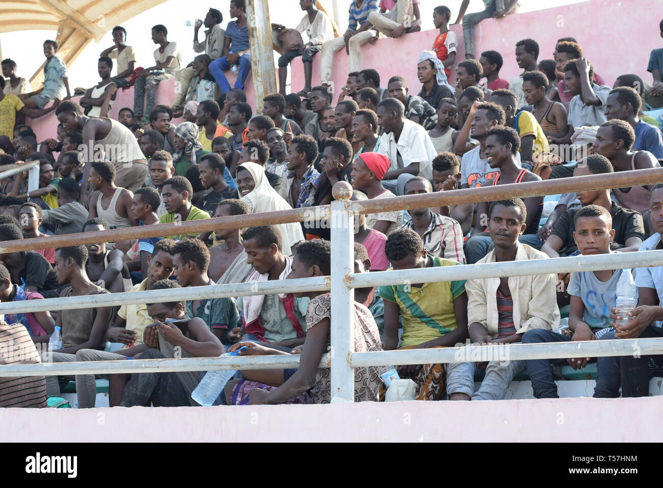 D'Aden, au Yémen. 22 avr, 2019. Les migrants africains illégaux détenus par les autorités locales de sécurité sont vus à un stade et attendre d'être transférés dans leur pays, dans la ville d'Aden, Yémen, le 22 avril 2019. Des centaines de migrants africains illégaux continuent à affluer en plusieurs provinces yéménites du sud malgré le conflit militaire en cours en cours dans le pays arabe ravagé par la guerre. Credit : Murad Abdo/Xinhua/Alamy Live News Banque D'Images