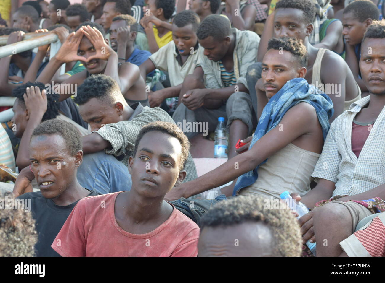 D'Aden, au Yémen. 22 avr, 2019. Les migrants africains illégaux détenus par les autorités locales de sécurité sont vus à un stade et attendre d'être transférés dans leur pays, dans la ville d'Aden, Yémen, le 22 avril 2019. Des centaines de migrants africains illégaux continuent à affluer en plusieurs provinces yéménites du sud malgré le conflit militaire en cours en cours dans le pays arabe ravagé par la guerre. Credit : Murad Abdo/Xinhua/Alamy Live News Banque D'Images