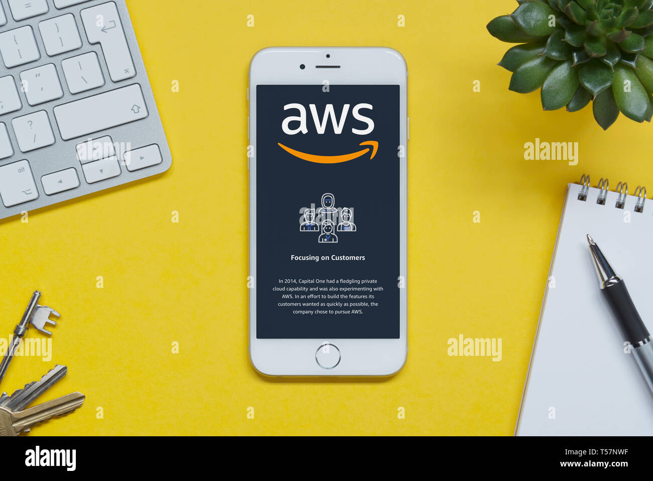 Un iPhone montrant le site Amazon Web Services repose sur un fond jaune table avec un clavier, les touches, le bloc-notes et des plantes (usage éditorial uniquement). Banque D'Images Un iPhone montrant le site Amazon Web Services repose sur un fond jaune table avec un clavier, les touches, le bloc-notes et des plantes (usage éditorial uniquement). Banque D'Images