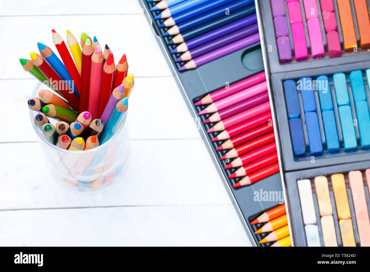 Crayons de couleur multi dans le bocal sur la table en bois, dans des tons pastels et crayons fort on background Banque D'Images