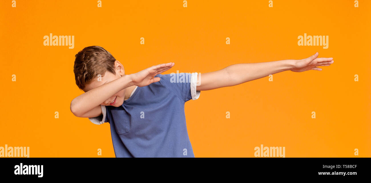 Teen boy throwing dab propose, sur fond orange Banque D'Images