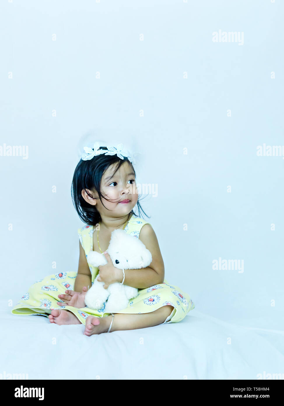 Portrait of cute asian little girl hugging son ami ours en peluche, une tourné Banque D'Images