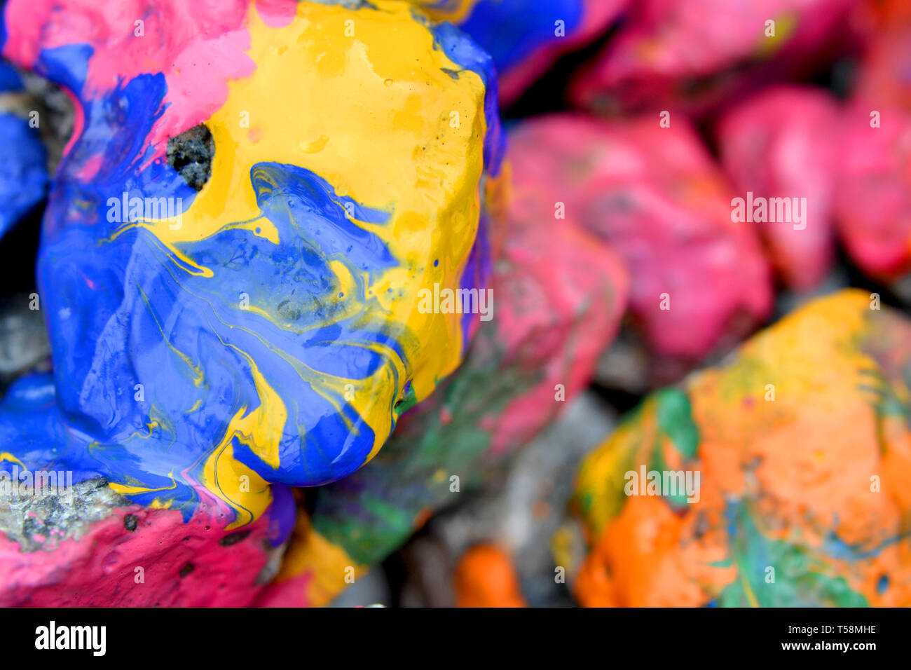 Rochers couverts de peinture colorée close-up. Des pierres dans la peinture avec des stries. Abstract background Banque D'Images