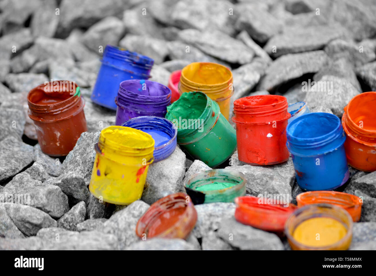 Petits pots de couleur de la peinture peut se coucher sur un caillou gris close-up Banque D'Images