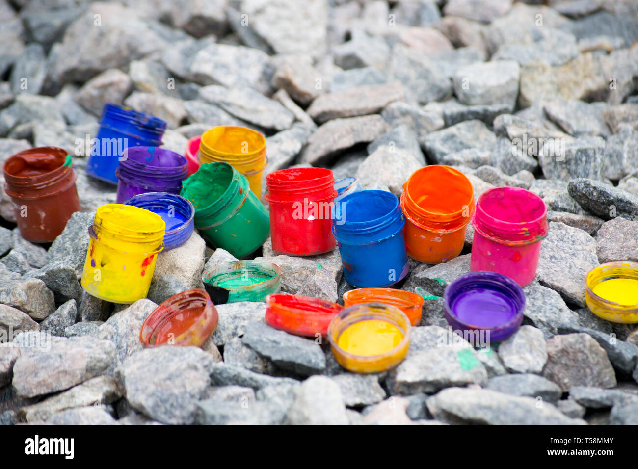 Petits pots de couleur de la peinture peut se coucher sur un caillou gris close-up Banque D'Images