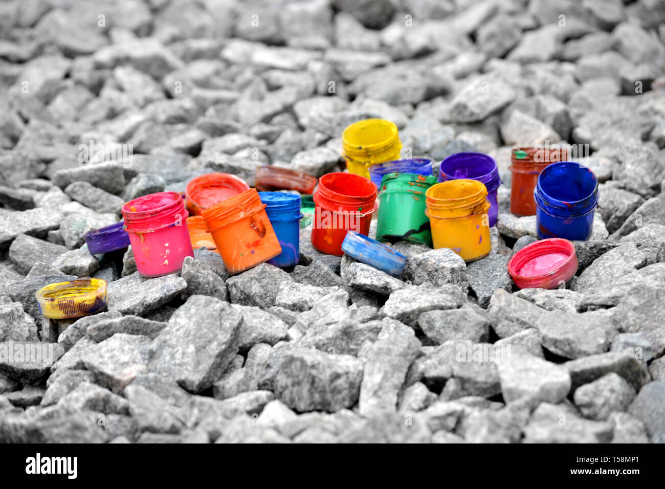 Petits pots de peinture dans le cadre de couleurs différentes sur les cailloux gris Banque D'Images