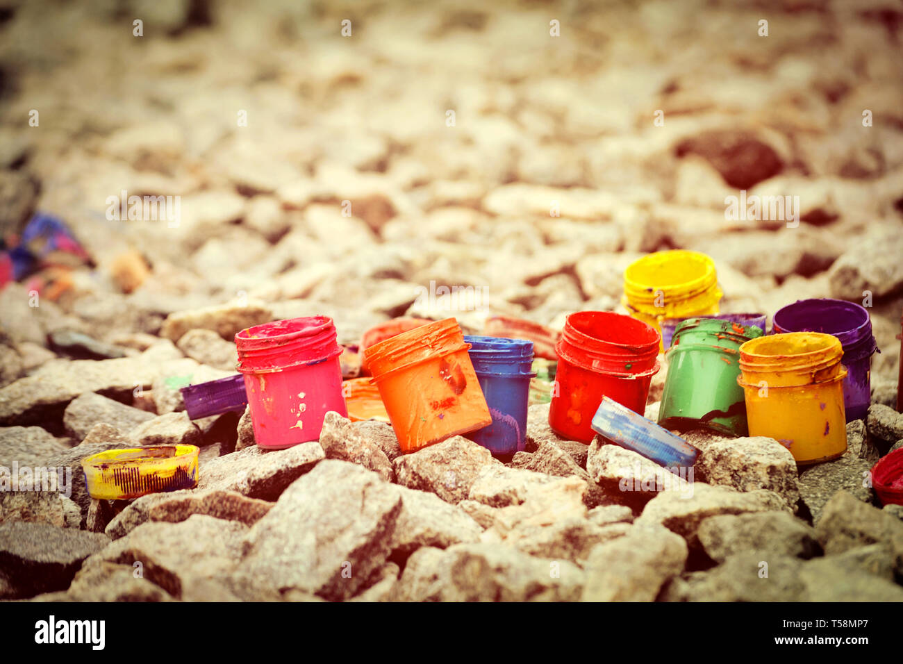 Petits pots de peinture dans le cadre de couleurs différentes sur les cailloux gris Banque D'Images