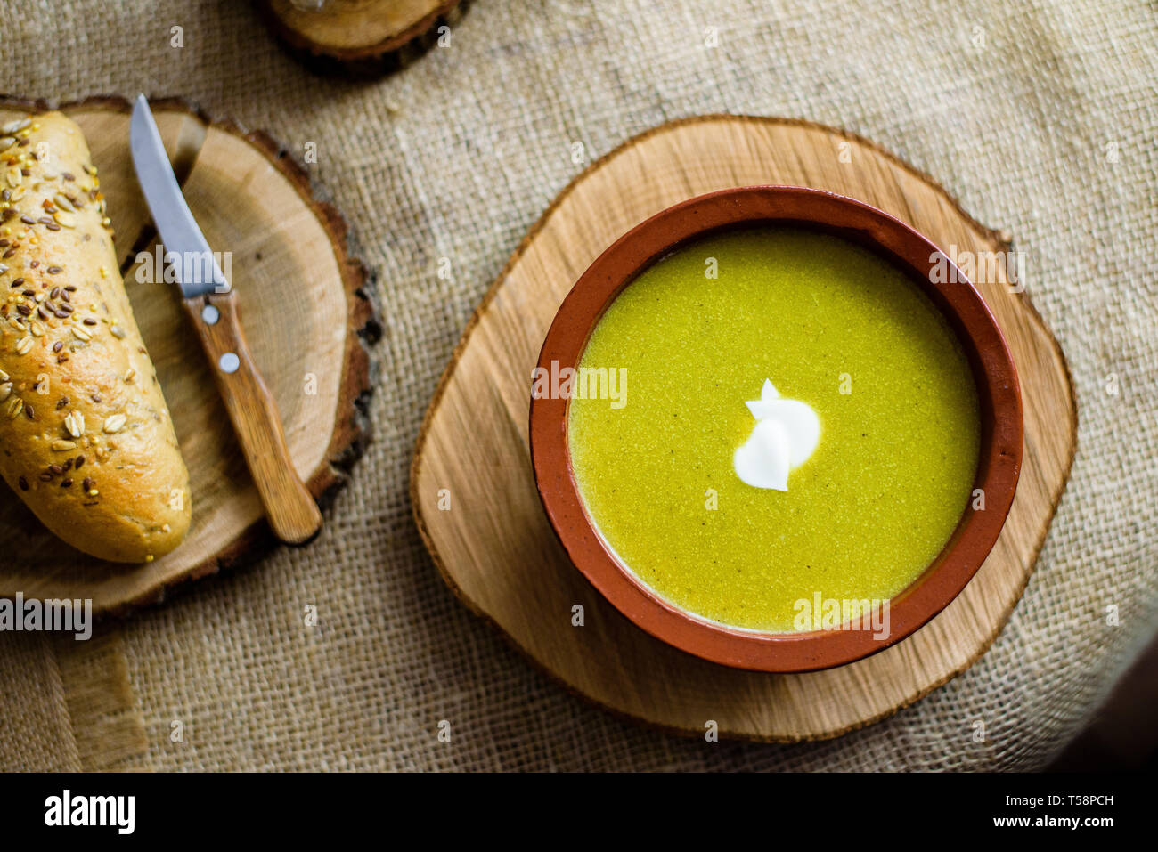 Brocoli soupe de légumes verts bio dans un bol en céramique. Plaque de bois avec de délicieux croûtons de pain. Alimentation biologique, végétalien plat. Banque D'Images