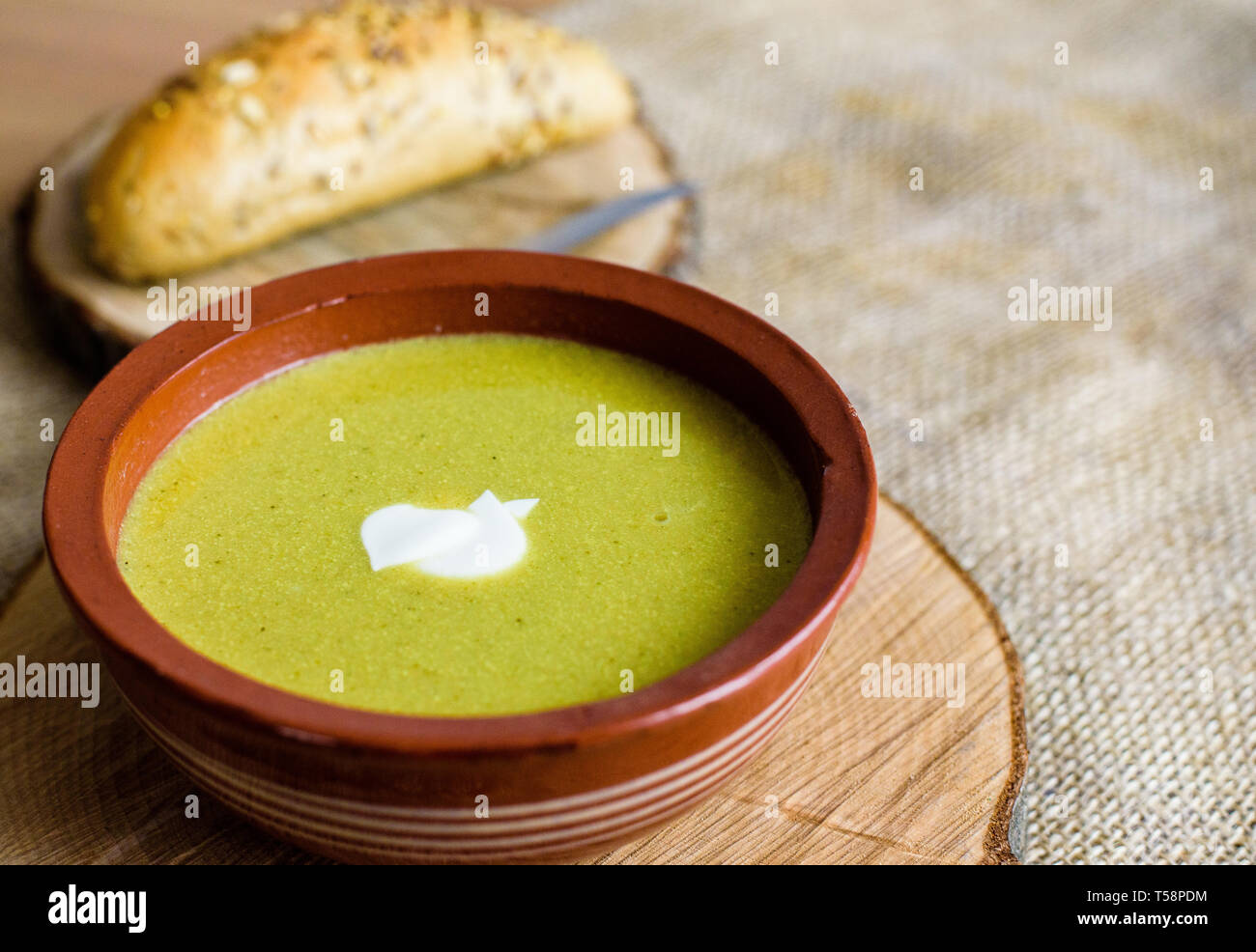 Brocoli soupe de légumes verts bio dans un bol en céramique. Plaque de bois avec de délicieux croûtons de pain. Alimentation biologique, végétalien plat. Banque D'Images