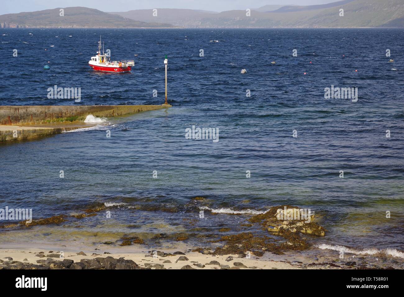 Petit bateau de pêche rouge à Elgol, vue sur le Loch Scavaig à l'Cullin Hills au-delà. Isle of Skye, Scotland, UK. Banque D'Images