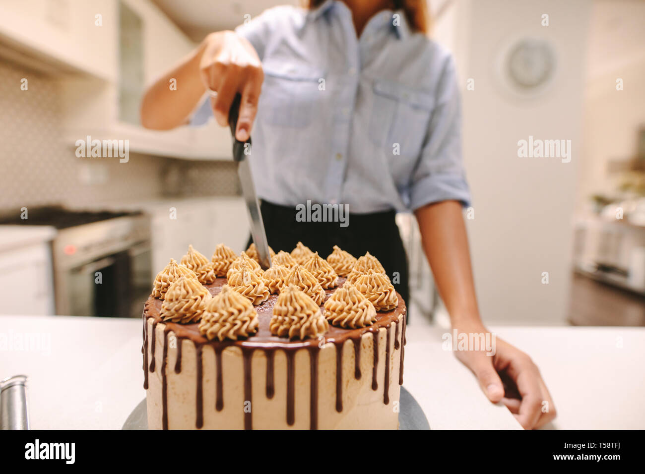 Femme chef de couper un gâteau en cours de cuisson dans la cuisine à la maison. Close up of vegetables parti gâteau fraîchement faite à l'aide d'un couteau. Banque D'Images