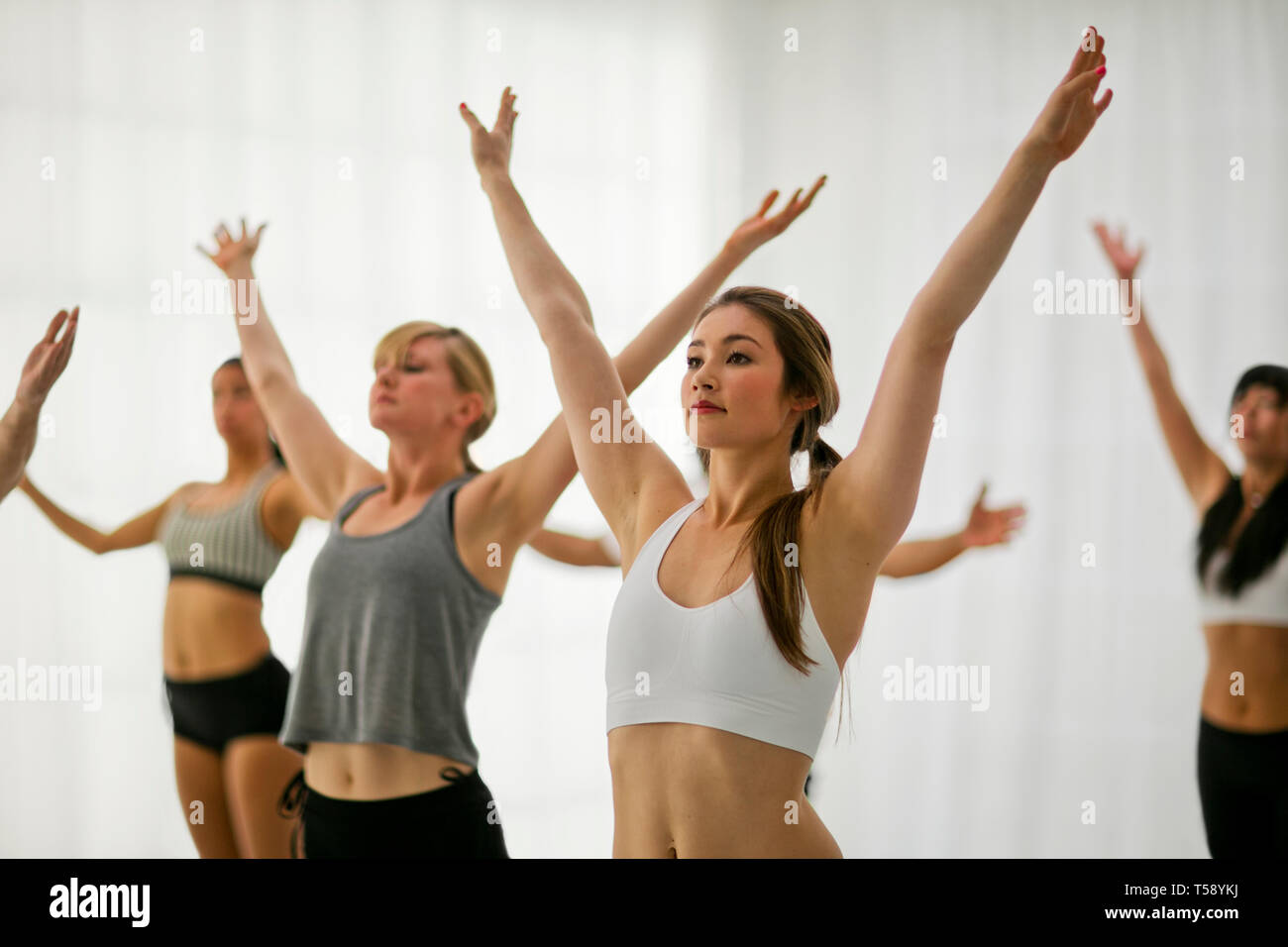 Jeune femme se concentre sur son posent alors qu'elle assiste à un cours de yoga. Banque D'Images