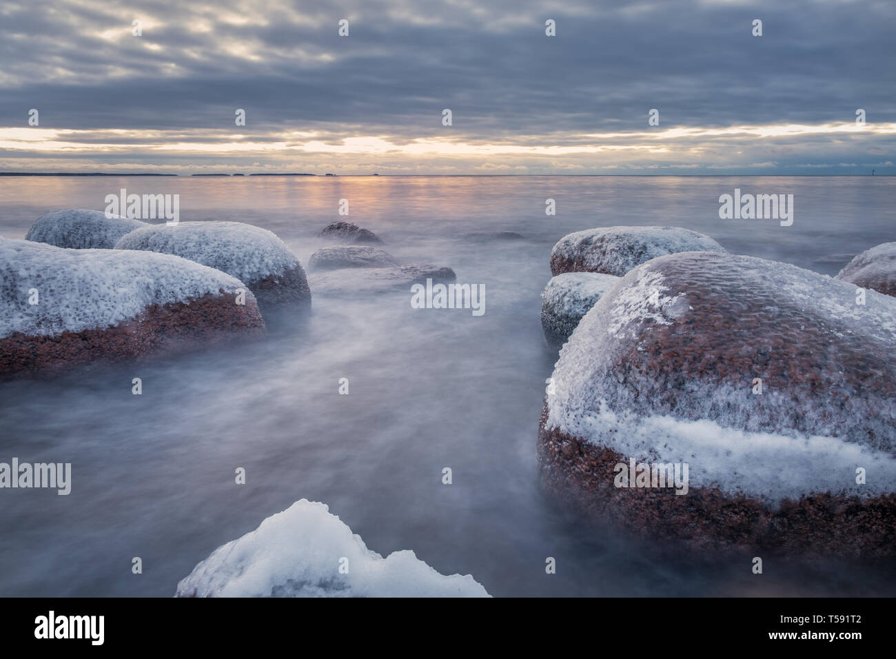 Paysage d'hiver panoramique avec vue sur la mer et le lever du soleil au matin. Belle Lumière avec rocky coast en Finlande. Banque D'Images Paysage d'hiver panoramique avec vue sur la mer et le lever du soleil au matin. Belle Lumière avec rocky coast en Finlande. Banque D'Images