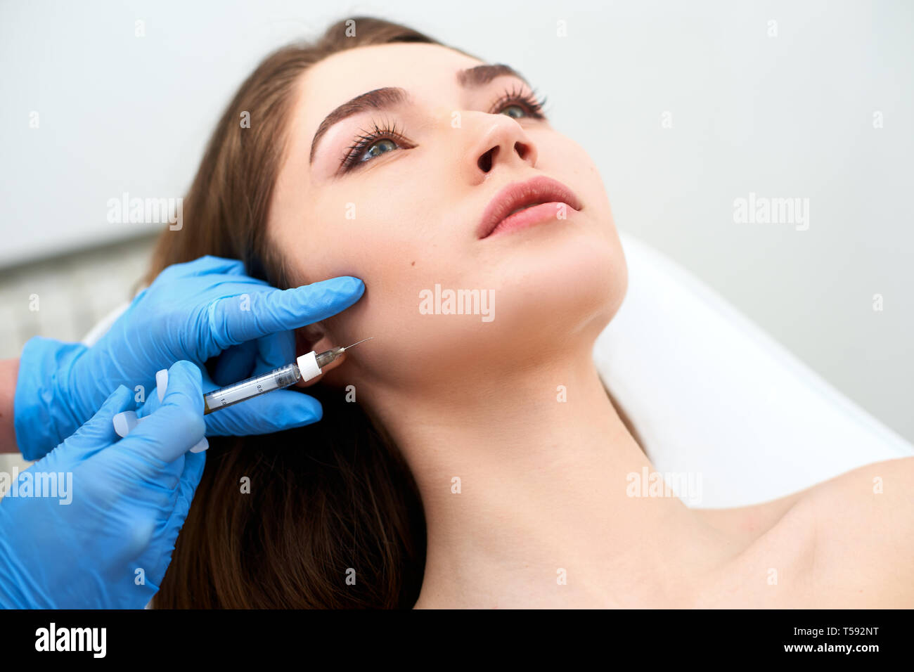 Médecin coiffeur avec seringue de remplissage d'injection des bajoues. Lignes masséters et réduction de contourage. traitement visage Traitement anti-vieillissement et le visage Banque D'Images