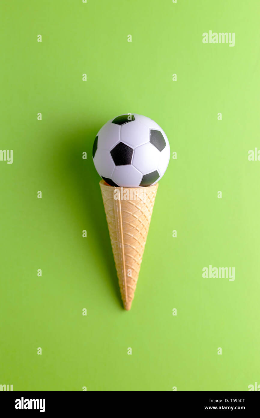 Cornet de crème glacée avec ballon de soccer sur fond vert Photo Stock -  Alamy