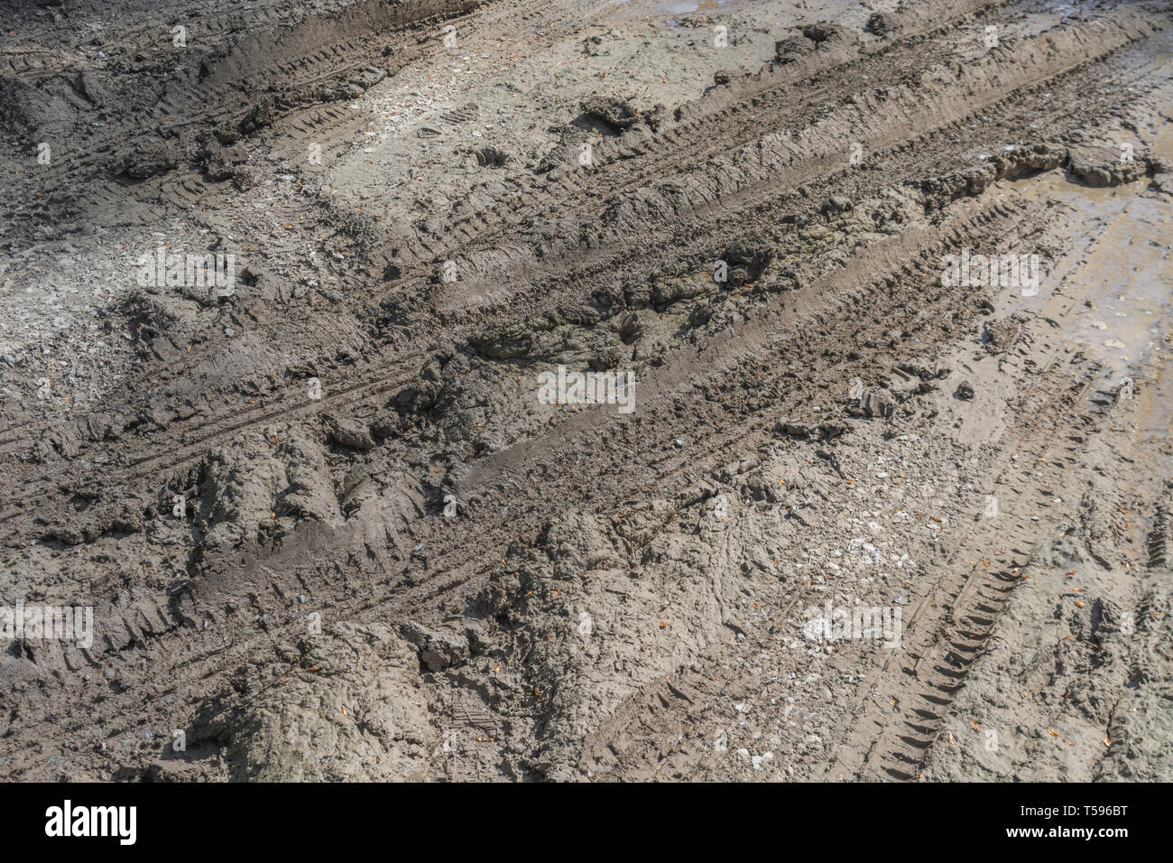 Des traces de pneus humides boueux sur la voie du pays. Coller dans la métaphore de la boue, enlisés vers le bas, terre boueuse. Banque D'Images