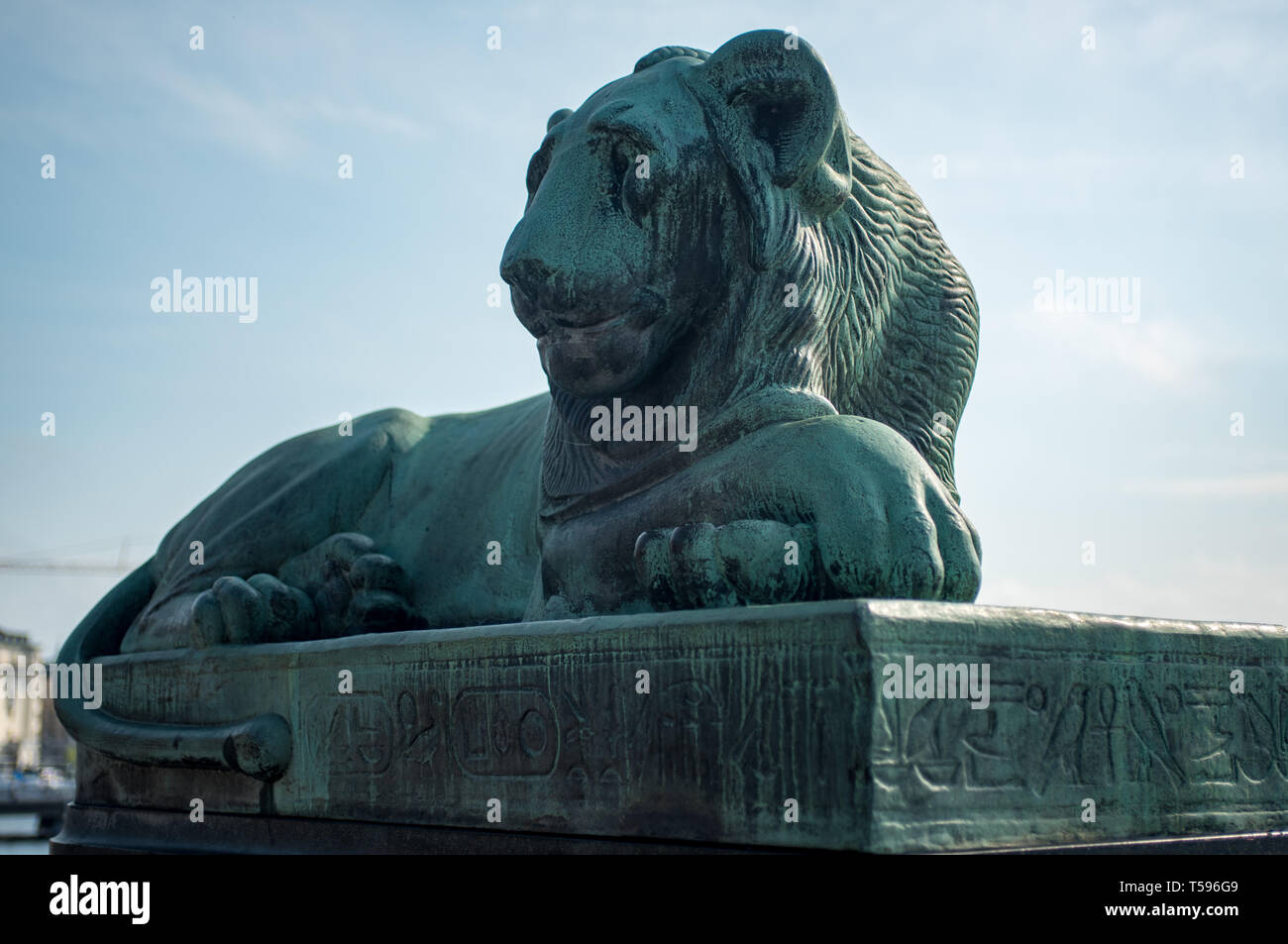 L'un des deux lions en bronze égyptien qui sont assis de chaque côté du pont Norrbro (Nord). Datant de 1926, la base est inscrit avec hiéroglyphes. Banque D'Images