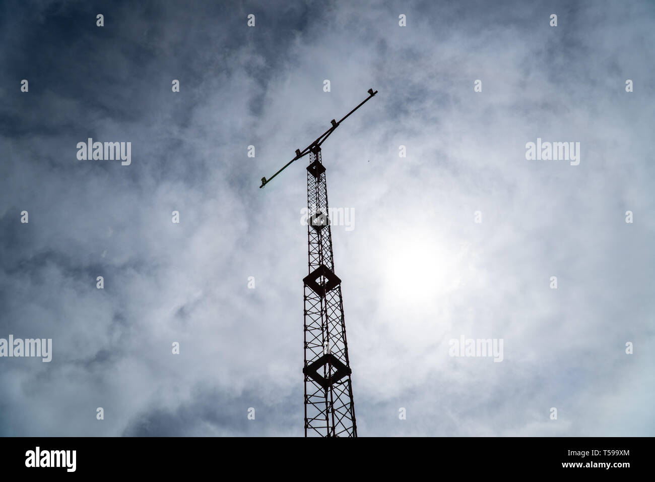 Silhouette d'un phare d'atterrissage de l'aéroport tour contre ciel nuageux. L'équipement de sécurité de l'aéroport Banque D'Images
