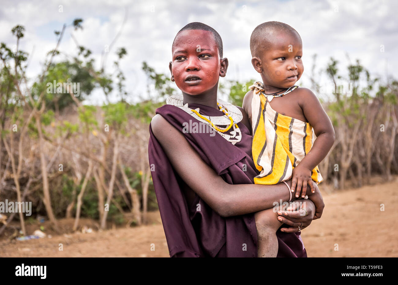 VILLAGE MASAI, KENYA - 11 octobre 2018 : Unindentified femme africaine avec un enfant portant des vêtements traditionnels en tribu Masai, Kenya Banque D'Images