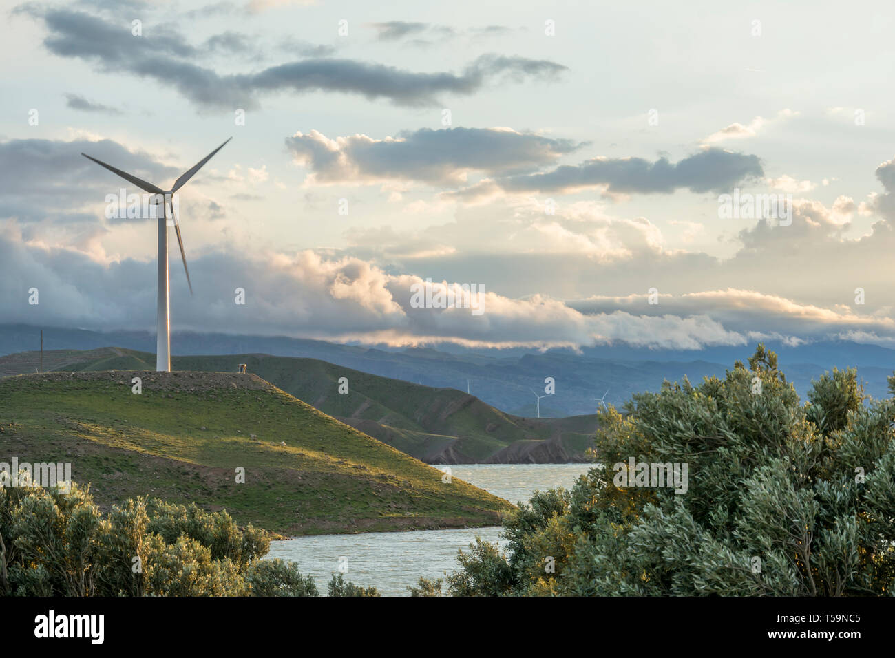 La turbine de vent sur la colline en face de ciel nuageux, la production d'électricité respectueuse de l'environnement Banque D'Images