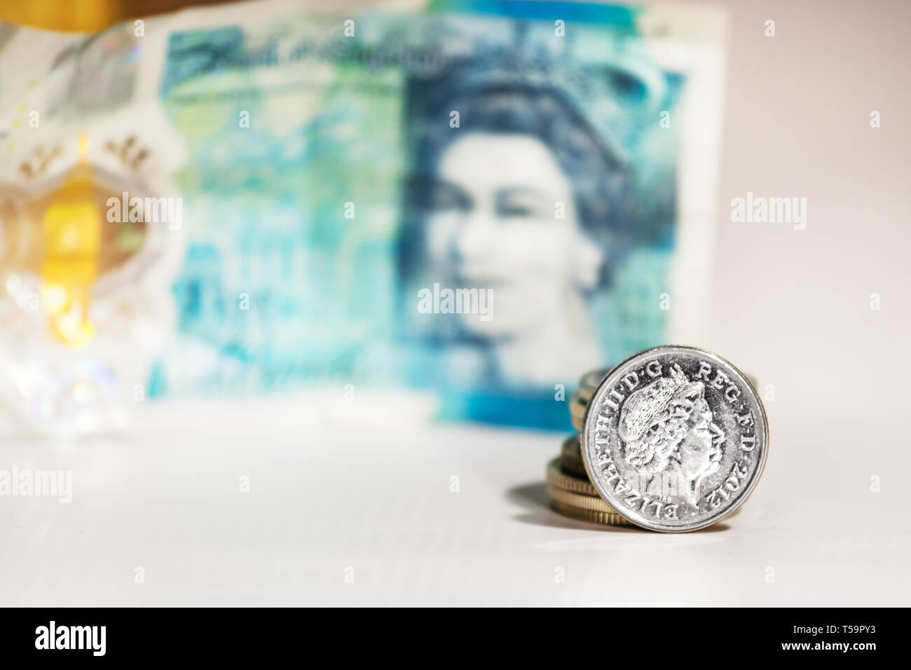 Une pièce de cinq pence avec l'image d'Elizabeth II sur un flou cinq livres de UK. Banque D'Images