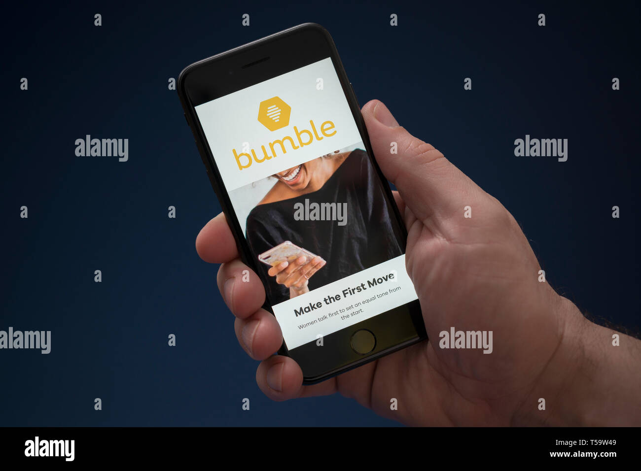 Un homme se penche sur son iPhone qui affiche le logo de bourdons (usage éditorial uniquement). Banque D'Images