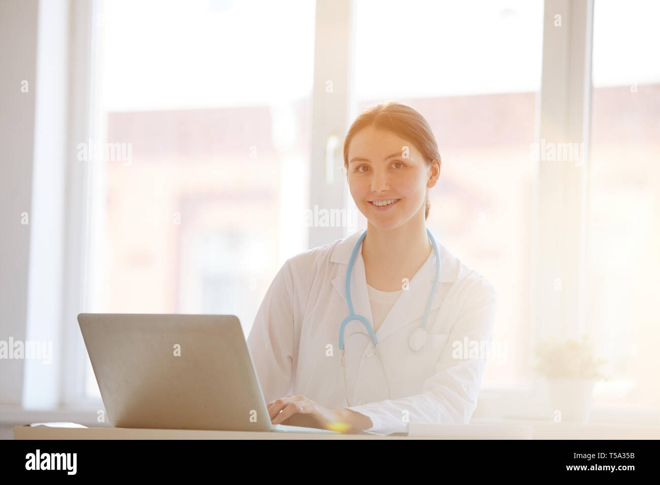 Woman Doctor Posing at Desk Banque D'Images