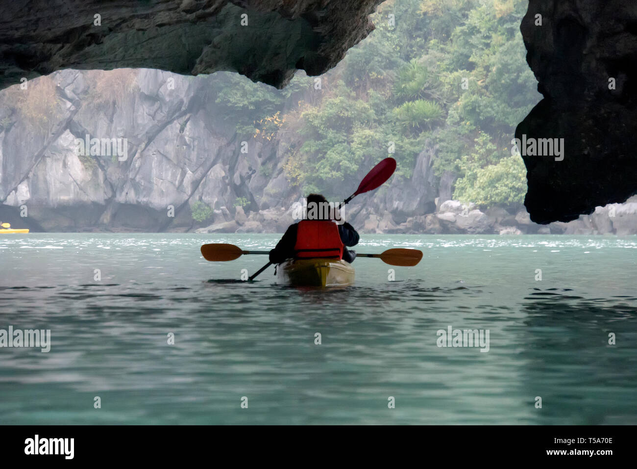 Couple sur le karst grotte découverte kayak et en tenant photograps dans le bateau. La baie d'Ha Long, Vietnam, Ile de Cat Ba Banque D'Images