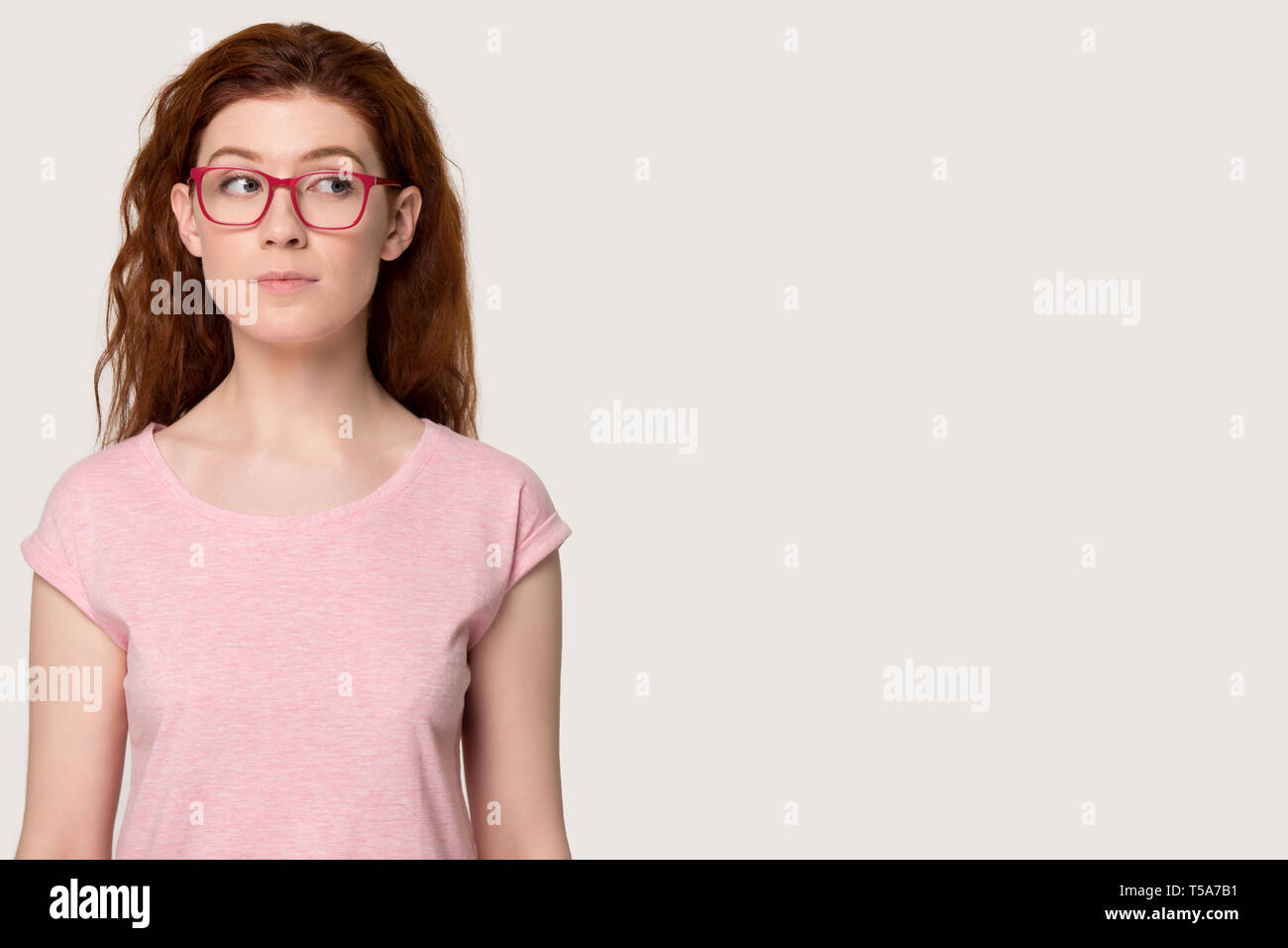 Pensive redhead girl à verres pense que de vente Banque D'Images