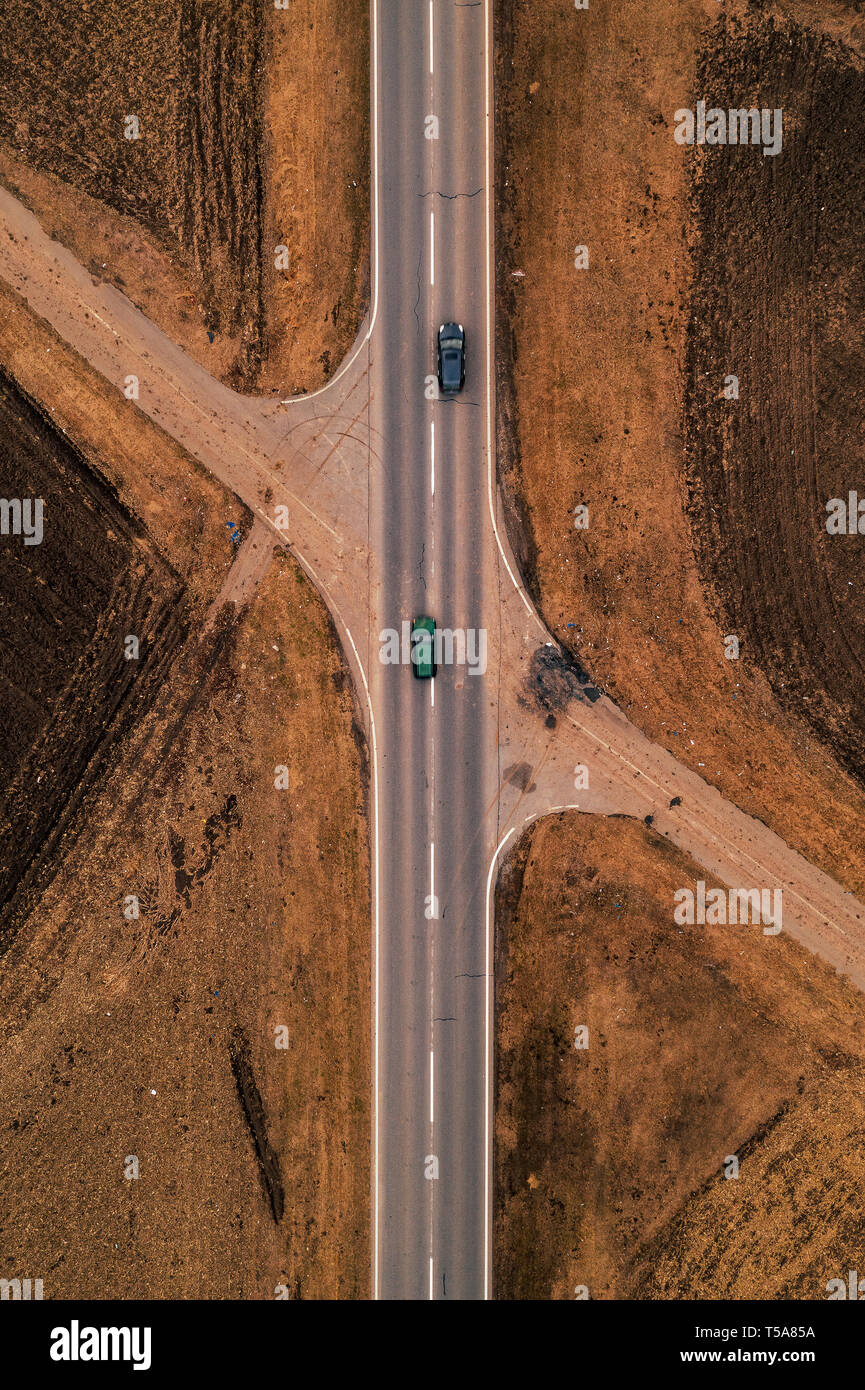 Deux voitures sur route droite dans la campagne en automne d'après-midi, vue aérienne du pov de drones Banque D'Images
