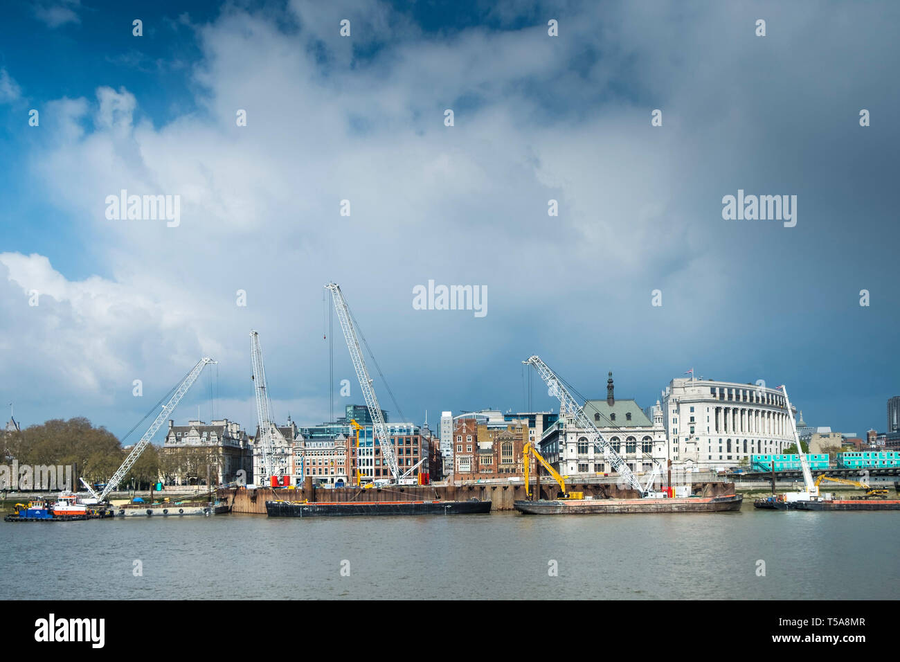 Grues sur des barges sur la Tamise à travailler sur l'installation du nouveau Super Sewer sur l'Albert Embankment à Londres. Banque D'Images