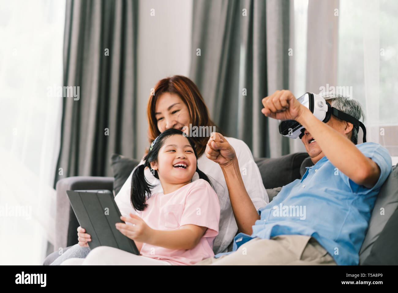 Belle heureux gens jouer ensemble de jeux virtuels, jeune fille, grand-père portant un casque VR. La vie de famille concept Banque D'Images