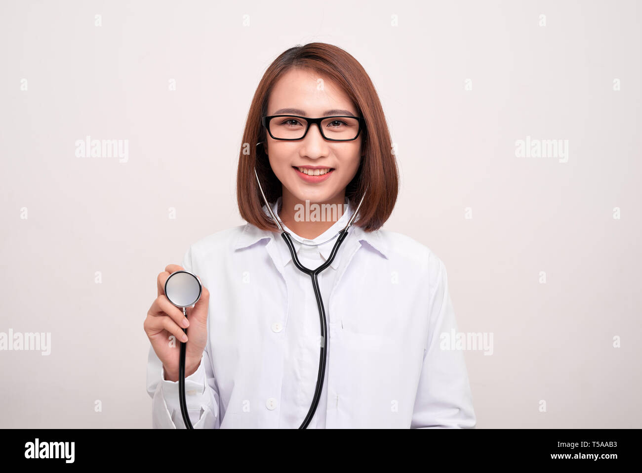 Jeune médecin woman holding stethoscope isolé sur fond blanc Banque D'Images