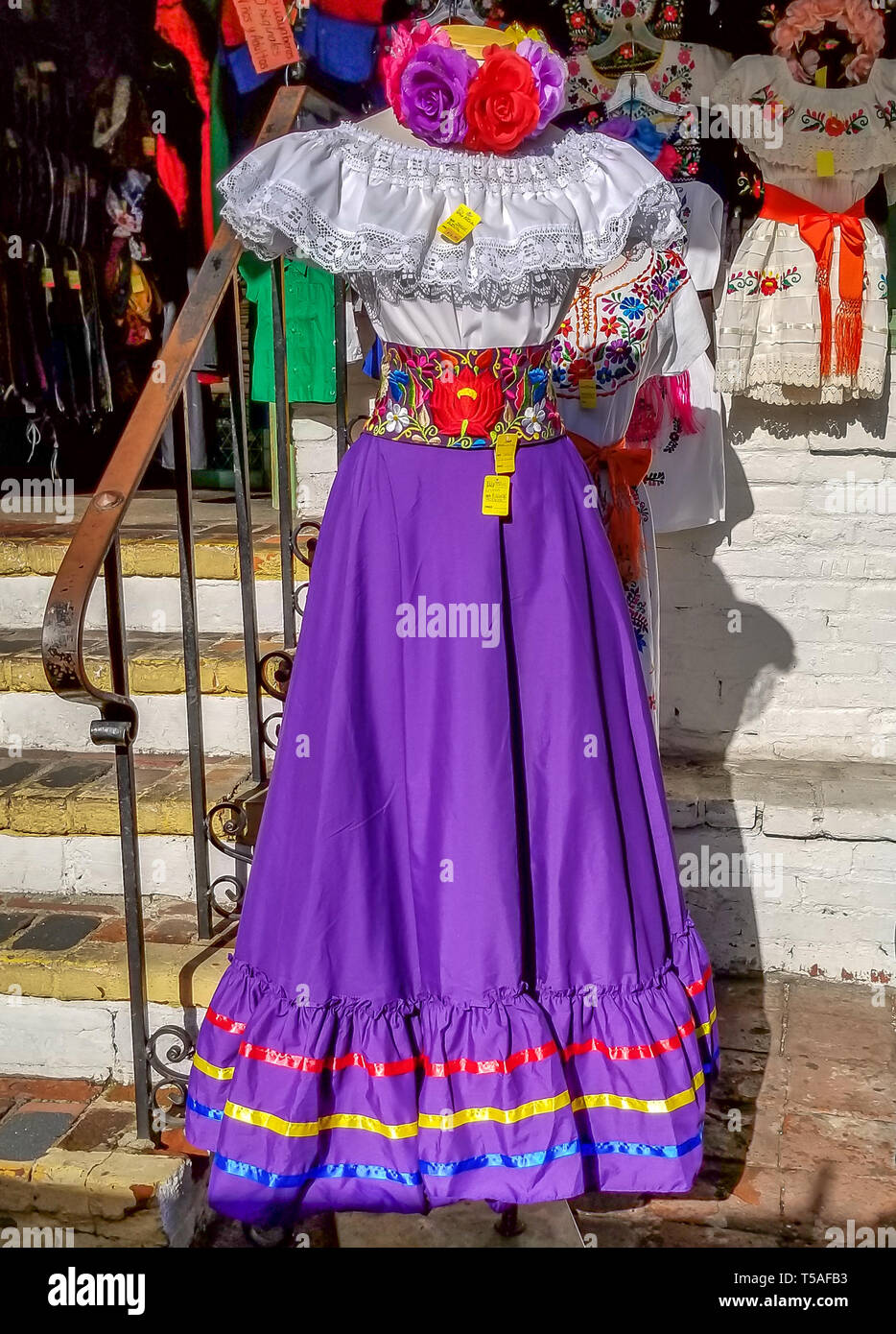 Robe traditionnelle mexicaine coloré en vente sur Olivera Street, shopping dans le vieux Los Angeles, avec le violet jupe et chemisier blanc, ceinture détaillée. Banque D'Images