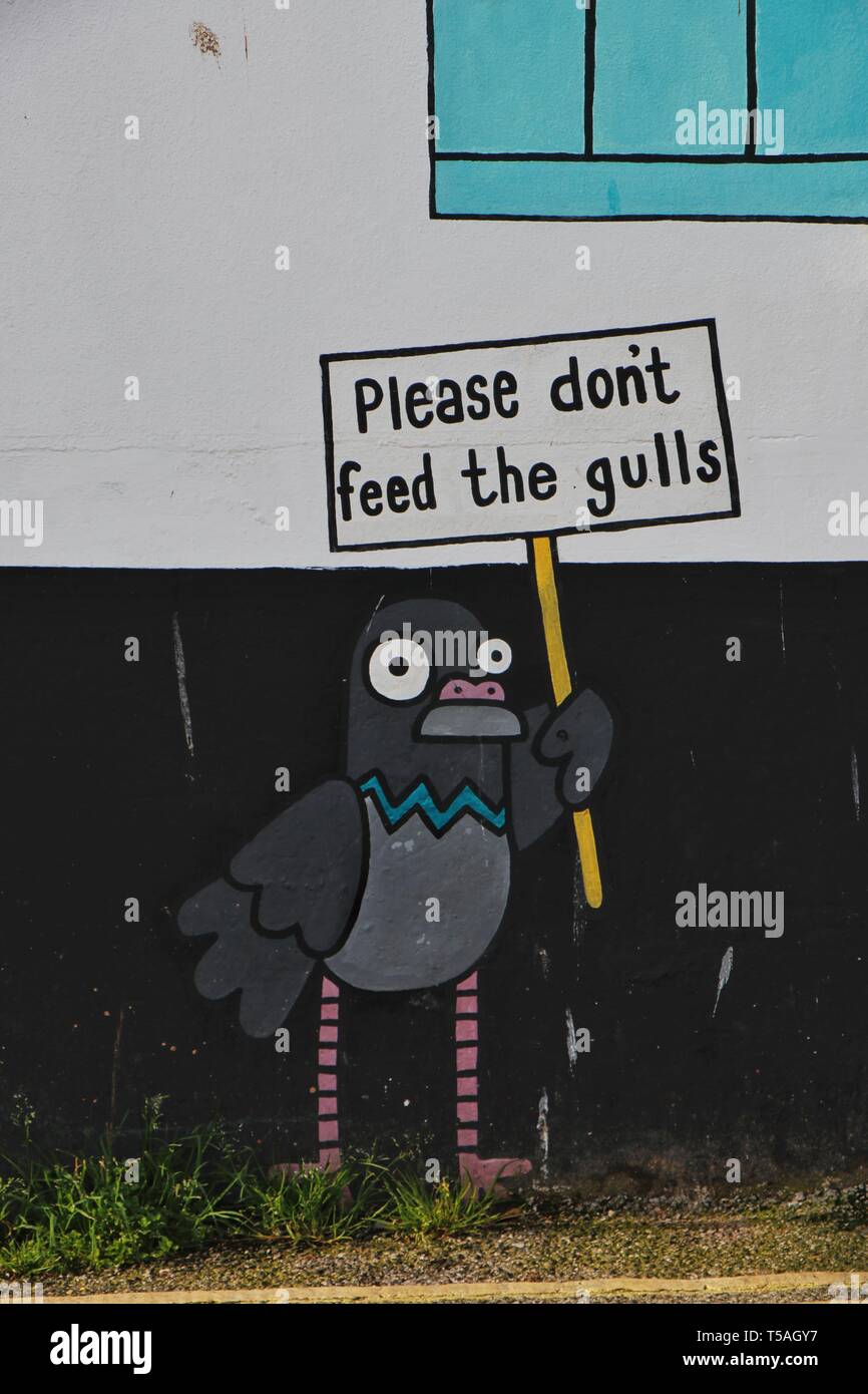 Ne pas nourrir les goélands. Dessin animé sur le côté d'un restaurant à Brixham Harbour, Devon. Banque D'Images