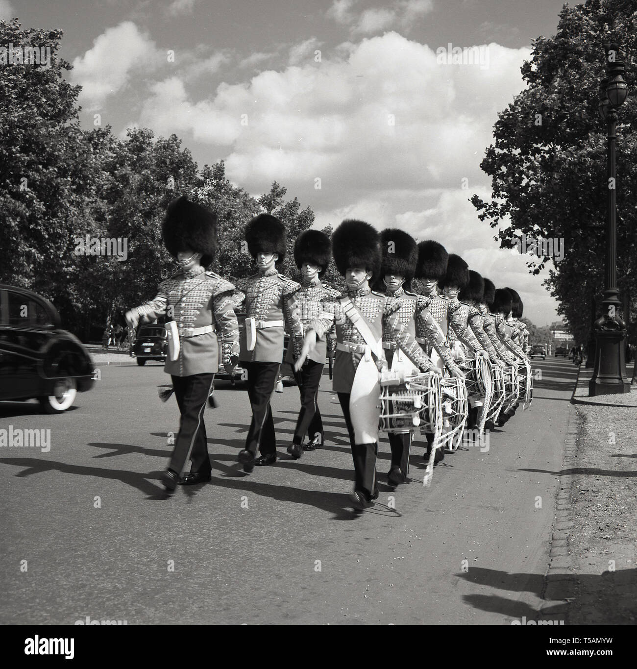 Années 1960, historique, 1er Bataillon Grenadier Guards corps de tambours en uniforme et casques bearskin marchant le long du Mall, route entre Buckingham Palace et Trafalgar Square, Londres, Angleterre, Banque D'Images