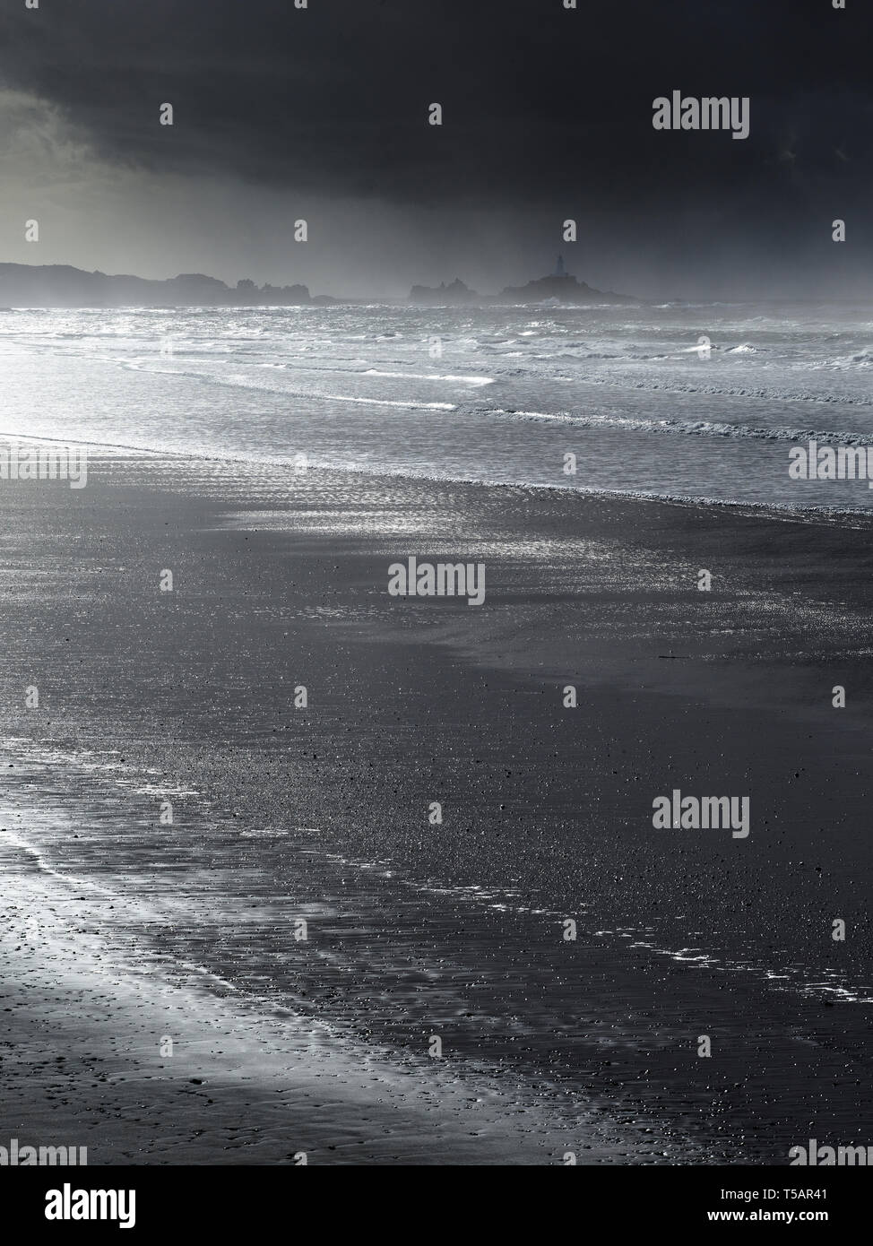 La baie de Saint-ouen à Jersey, Channel Islands, la plus longue plage de l'île, montrant la Corbiere Lighthouse au loin. Banque D'Images