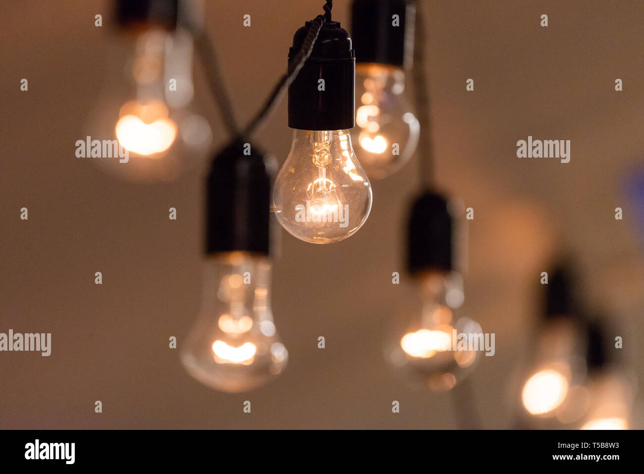 Vue rapprochée de vintage decorative ampoule lampe allumé sur le plafond à l'intérieur. Lampes transparentes rayonnant de lumière chaude. Banque D'Images