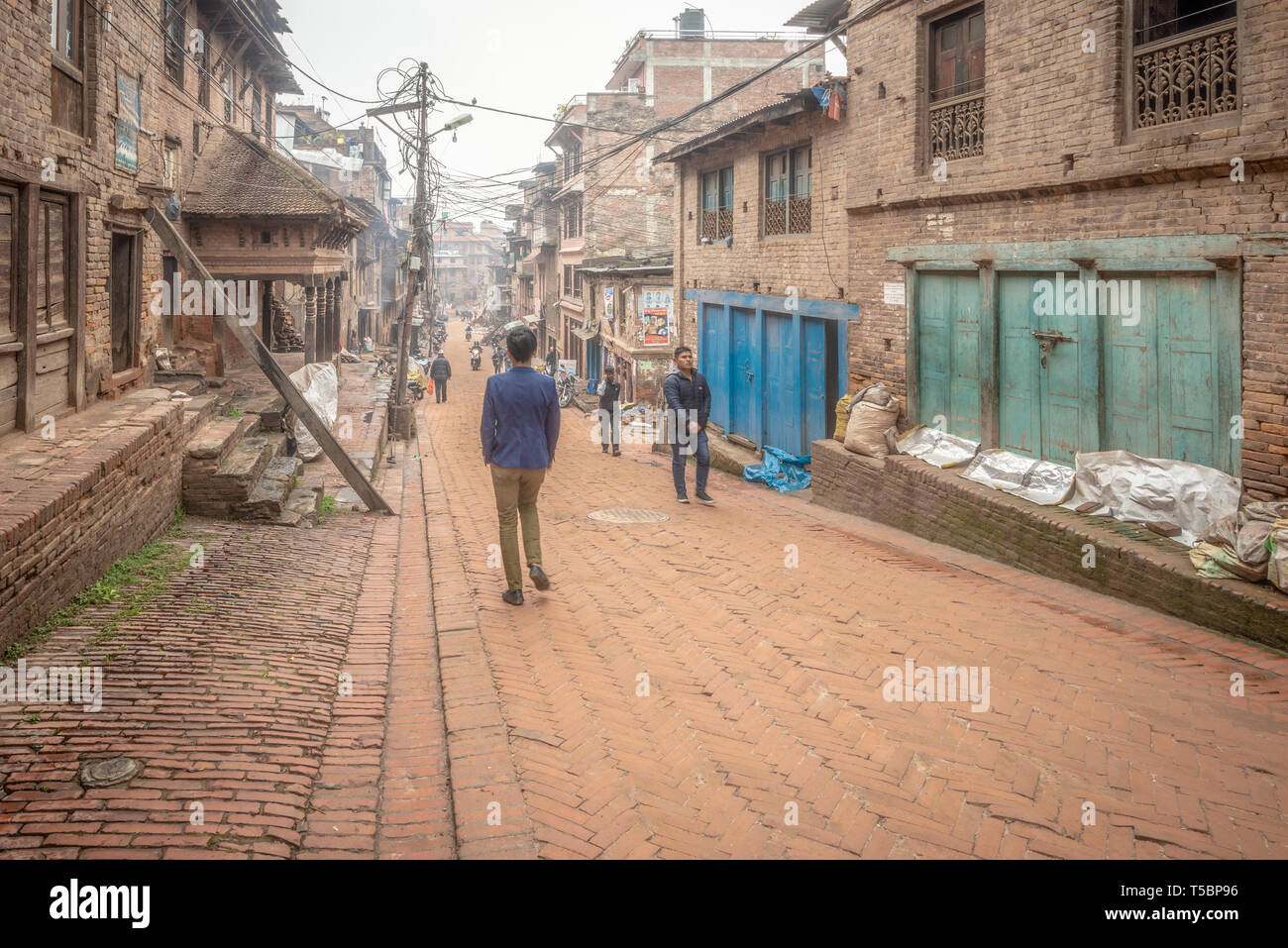 BHAKTAPUR, NÉPAL - 5 avril 2019 : Les passants entrant dans la vieille ville, pris dans un ciel couvert matin dans le centre historique Banque D'Images