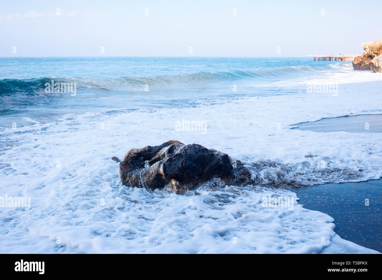 Plage de sable fin et des vagues de l'océan bleu avec mousse blanche. Banque D'Images